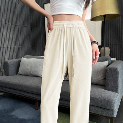 Pantalon en soie à taille haute, coupe étroite, ample, légèrement drapé et jambes droites.