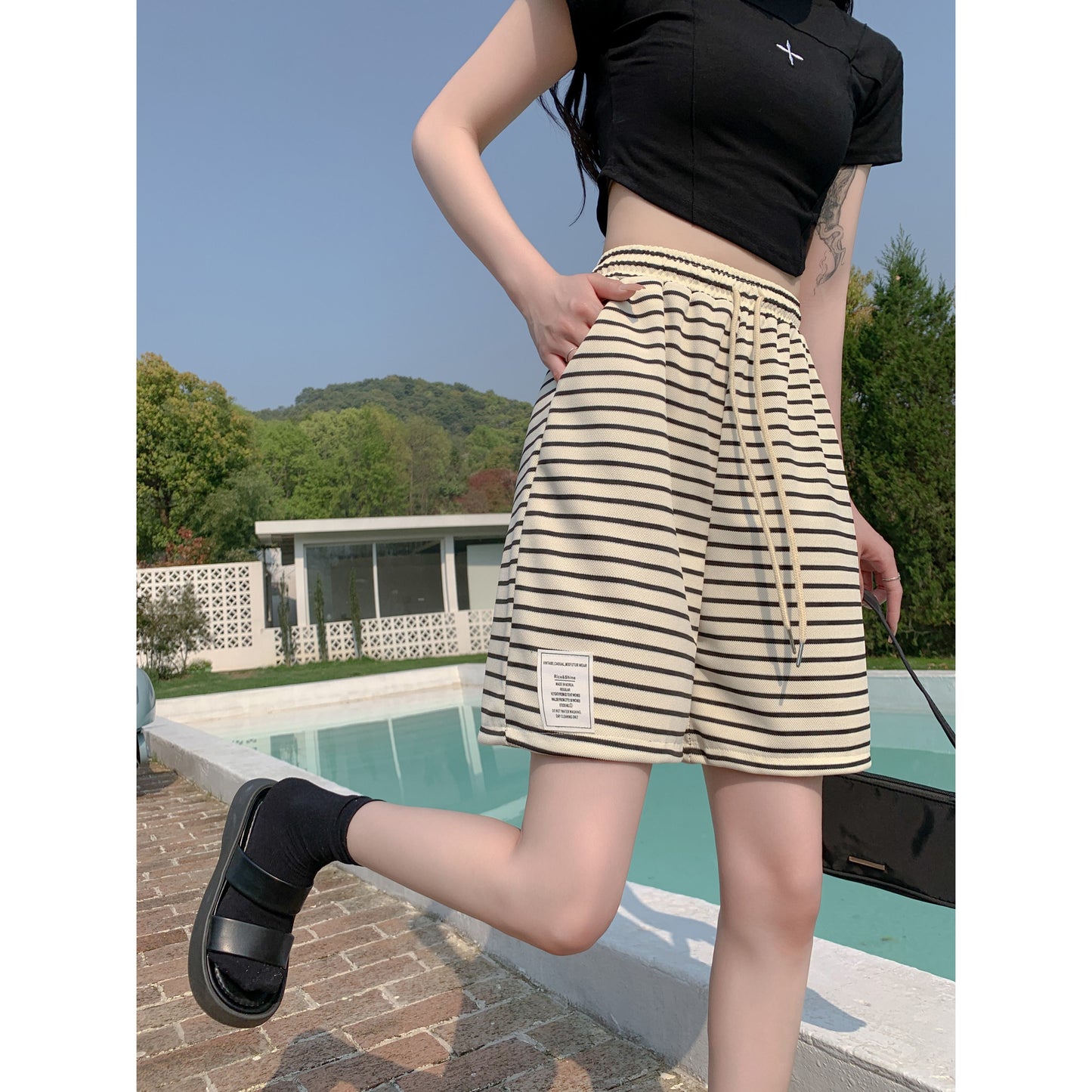 Shorts casuales de talle alto a rayas blancas y negras con pierna ancha y cintura elástica ajustable.