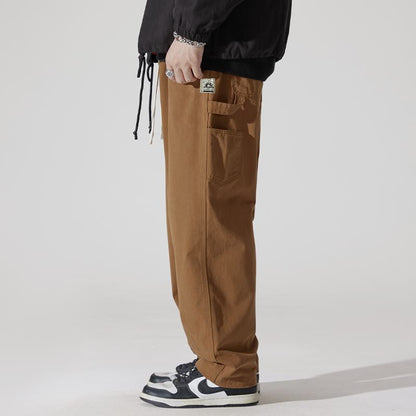 Pantalones de carga holgados con cintura ajustable y perneras anchas, detalle de etiqueta.