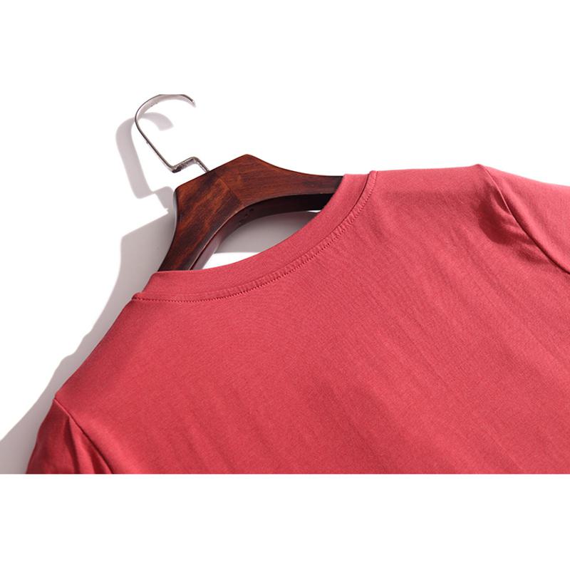 Camiseta de manga corta de algodón con cuello en V, botones y corte holgado para usar por fuera.