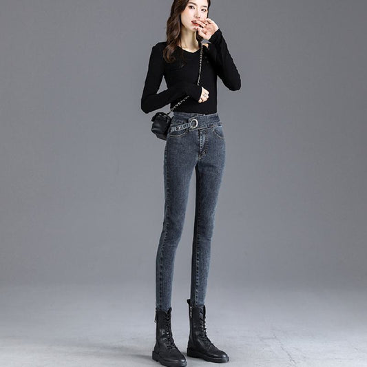 جينز ضيق من اللون الفاتح بخصر عالي يشد الجسم ويمنحه شكلاً نحيلًا.
