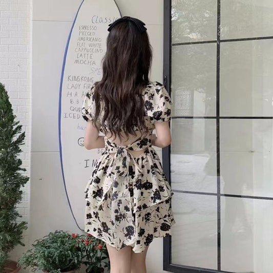 Kleid mit tailliertem Schnürbund, floralen Print, quadratischem Ausschnitt und ballonförmigen Ärmeln im Retro-Stil.
