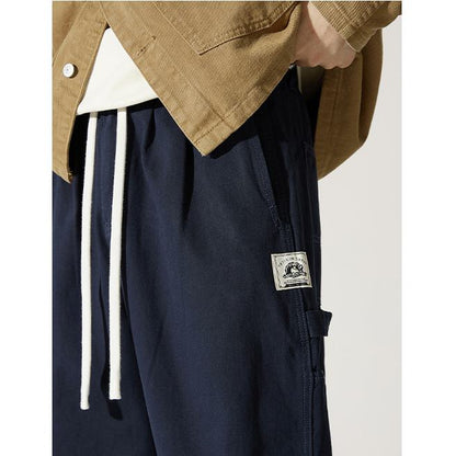 Pantalones de carga holgados con cintura ajustable y perneras anchas, detalle de etiqueta.