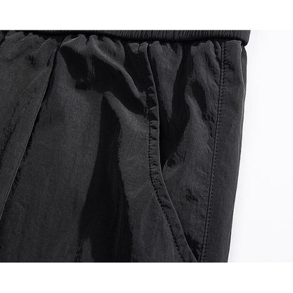 Pantalon cargo ample de couleur unie avec poches extensibles polyvalentes et élastiques.