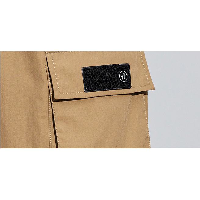 Pantalon cargo à fermeture éclair, poches multiples et élastique ajusté.