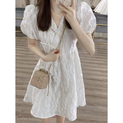 Weißes französisches Stil-Petite-Kleid mit ballonartigen Ärmeln und V-Ausschnitt.