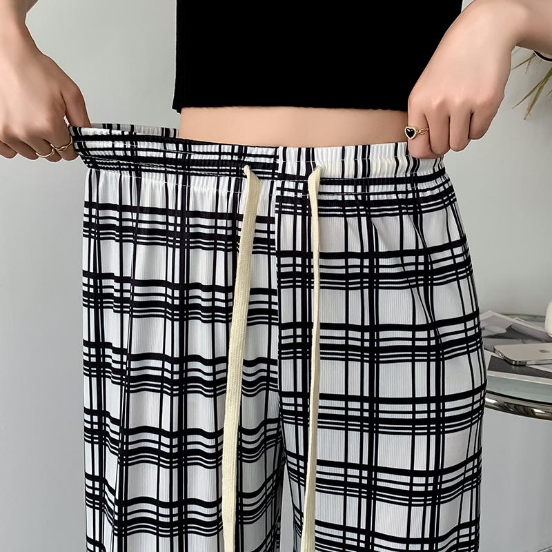 Pantalon à carreaux ample à taille haute en soie glacée pour une silhouette élancée.