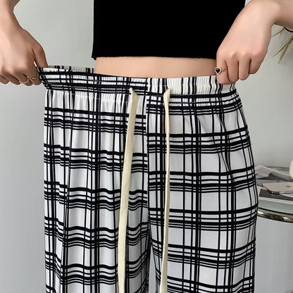 Pantalon à carreaux ample à taille haute en soie glacée pour une silhouette élancée.