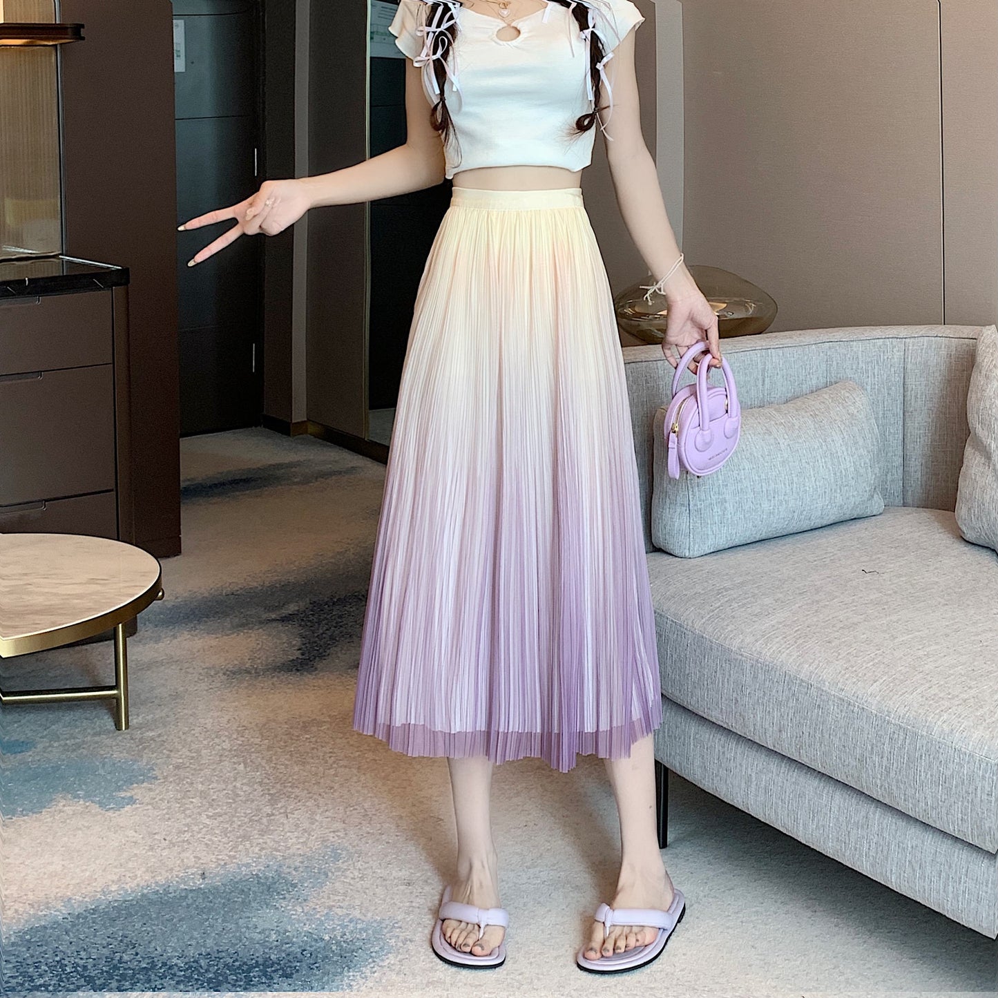 Falda plisada elegante con corte en A, falda completa con pliegues que estiliza la figura y presenta un degradado de colores.
