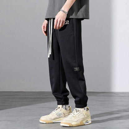 Pantalón deportivo holgado con bordado en forma de letra versátil.