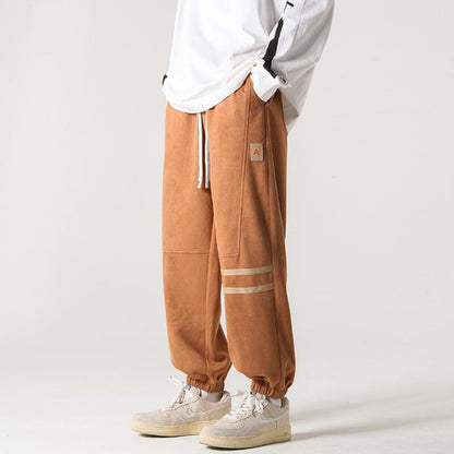 Pantalones deportivos con cintura elástica y confección versátil de gamuza sintética.