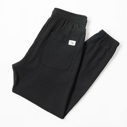 Pantalones cónicos de ajuste holgado con cintura elástica y elasticidad delgada.