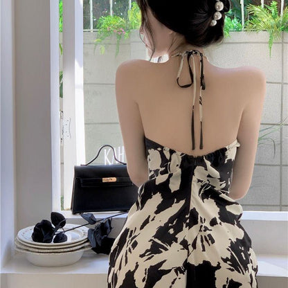 Klassisches A-Linien-Kleid mit floralem Print, taillierter Taille und rückenfreiem Design, in Midi-Länge.