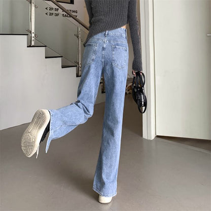 Schlankmachende, bodenlange, hoch taillierte Jeans mit weitem Beinschnitt und heller Farbe.