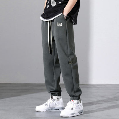 Pantalón deportivo holgado con bordado en forma de letra versátil.