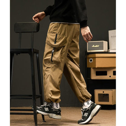 Pantalon cargo ample de couleur unie avec poches extensibles polyvalentes et élastiques.
