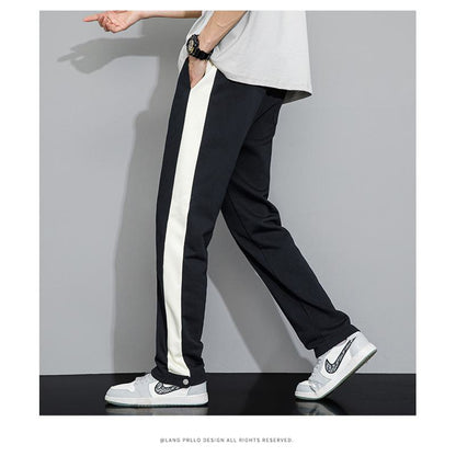 Pantalones rectos informales con rayas negras y parches deportivos laterales y corte holgado.