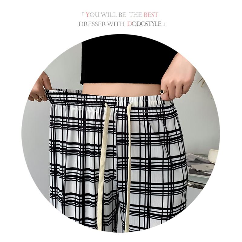 Pantalon à carreaux ample à taille haute en soie glacée pour une silhouette élancée.