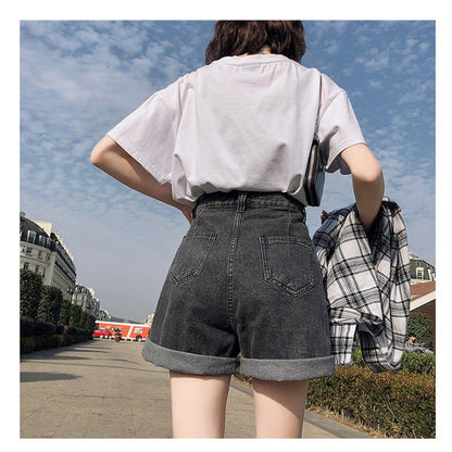 شورت جينز واسع بخصر عالٍ وقصة فضفاضة لتنحيف الجسم، يُرتدي في الخارج.