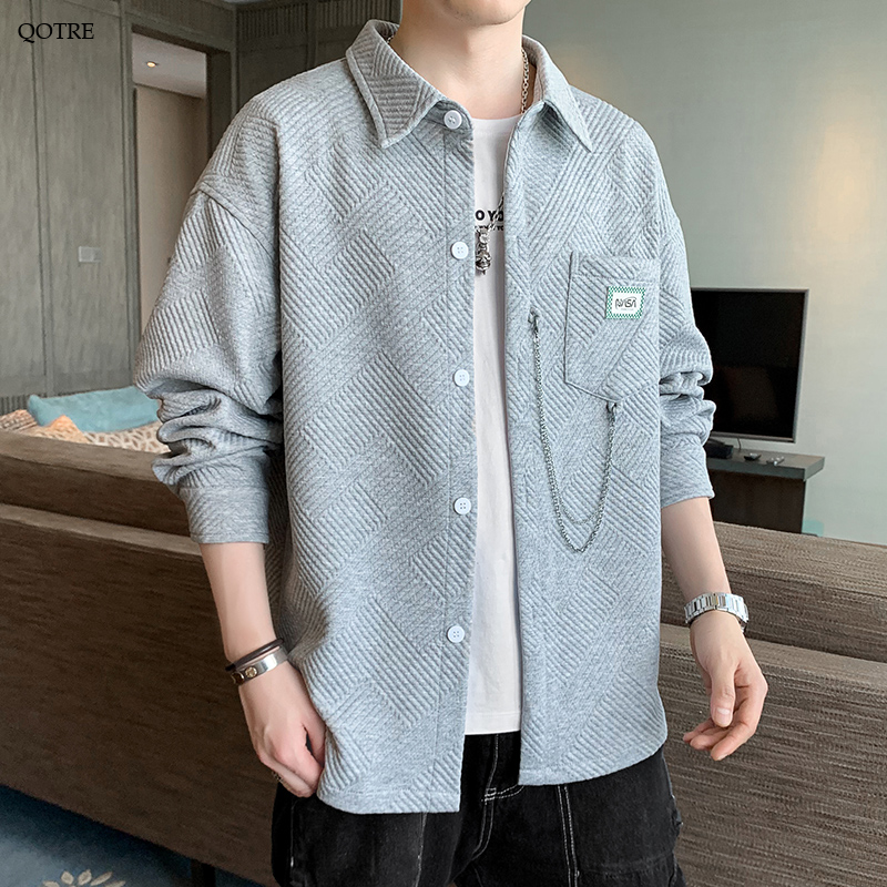 Camisa de manga larga con cuello extendido, corte holgado y bolsillos parchados.