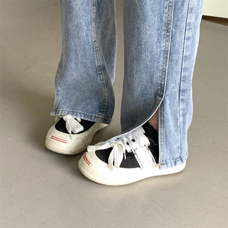 Jeans évasés à taille haute et de couleur claire, longs jusqu'au sol, qui amincissent la silhouette.