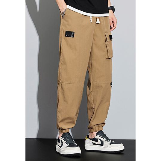 Pantalones de carga con cremallera y múltiples bolsillos elásticos y cónicos.